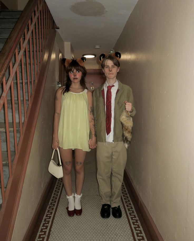 two people dressed in costumes are walking down the hallway