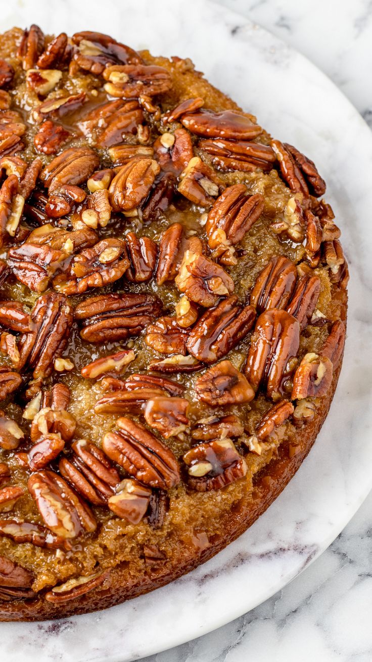 a cake with pecans on it sitting on a plate