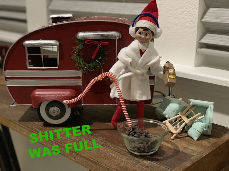 an elf with a red and white trailer behind him is holding a candy cane in his hand