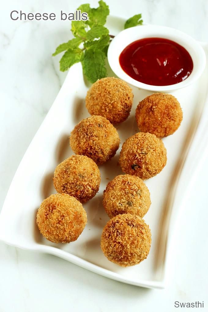 small appetizers on a white plate with ketchup and parsley in the background