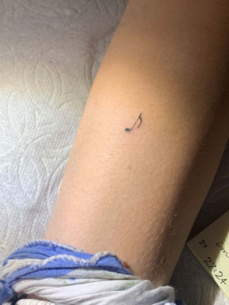 a woman's arm with a tiny tattoo on it