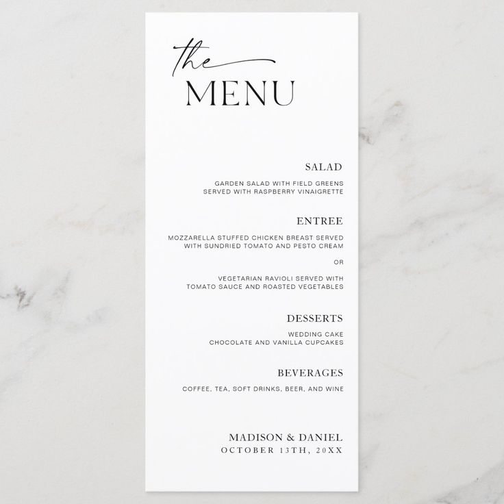 a white menu card with the word, the menu on it in black ink is sitting on a marble surface