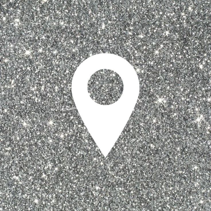 a white pin marker on a gray glittered surface with small stars in the background