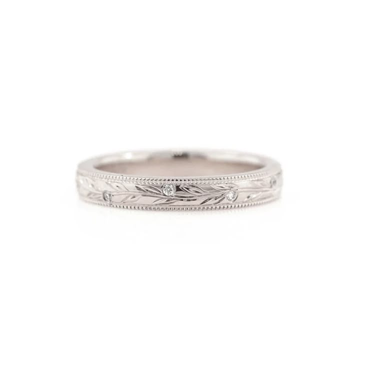 a white gold wedding band with engraved details