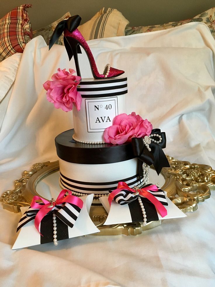 a white and black cake with pink flowers on top