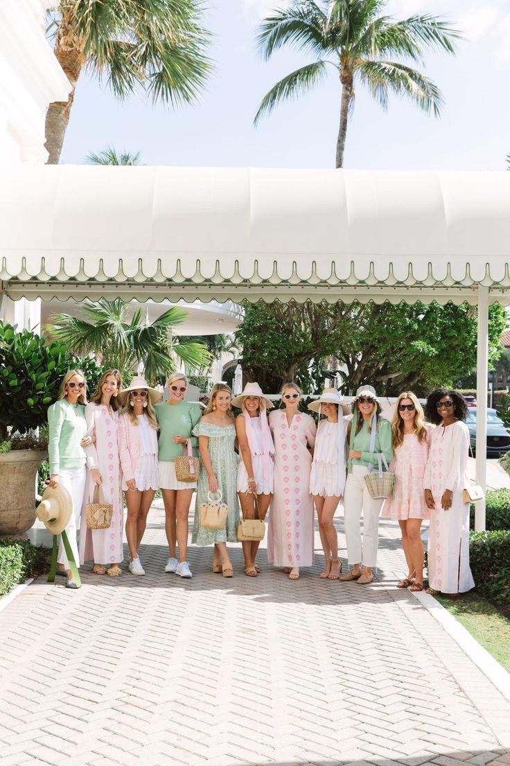 a group of women standing next to each other in front of a white gazebo