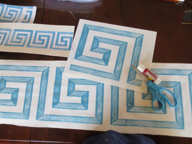 scissors and tape are laying on the floor next to some decorative tiles that have been cut into rectangles