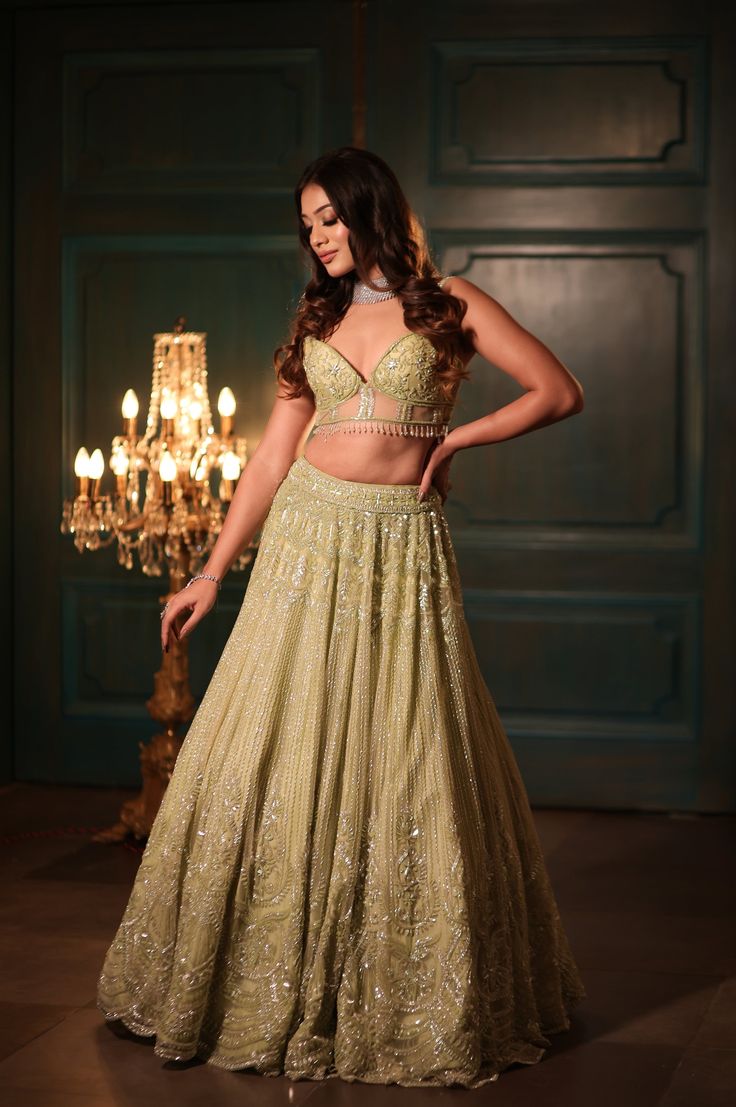 This pistachio green lehenga set features all-over sequin, crystal, cutdana, and bead embroidery. Paired with a dramatic feathered dupatta and strappy corset blouse embroidered with sequin and crystal detailing on net.DELIVERY TIMEPlease allow 8-12 weeks for your outfit to arrive.FABRIC DETAILSNetProfessional cleaning only. Lehenga Green, Corset Blouse, Green Lehenga, Pistachio Green, Bead Embroidery, Embroidered Blouse, Pistachio, Beaded Embroidery, Free Shopping