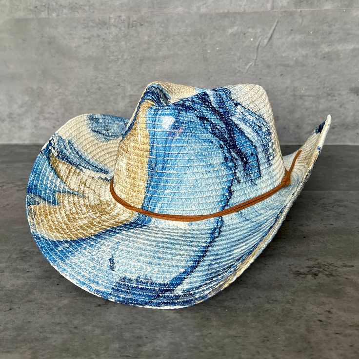 "Summer straw cowboy hat painted in Dallas, TX by a local artist. Glam gold paint and color marbled on a straw cowgirl hat with chin strap, topped with a double tan faux suede cord tied with a nautical knot. The cord is unattached so is easy to replace with your own strap.  This southern beachy sun hat has a modern bohemian look that is perfect for a western glam look, tropical resort casual, or city summer. How It's Made These hats are painted using a method called Hydro-Dipping. Each hat is in Blue Western Straw Hat With Curved Brim, Blue Western Straw Hat For Summer, Western Blue Straw Hat For Summer, Western Style Blue Straw Hat For Summer, Blue Western Straw Hat For Country Events, Western Blue Straw Hat For Country Events, Blue Wide Brim Straw Hat For Rodeo, Blue Hat Bands For Rodeo In Summer, Artisan Straw Hat For Ranch In Summer