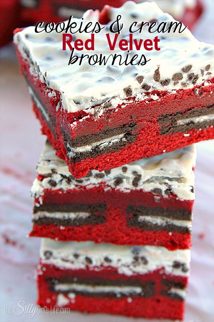 two red velvet brownies stacked on top of each other with white frosting and chocolate chips