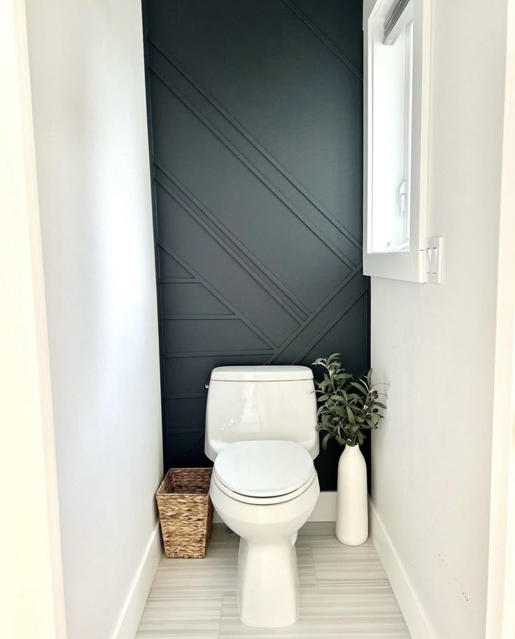 a white toilet sitting inside of a bathroom next to a window