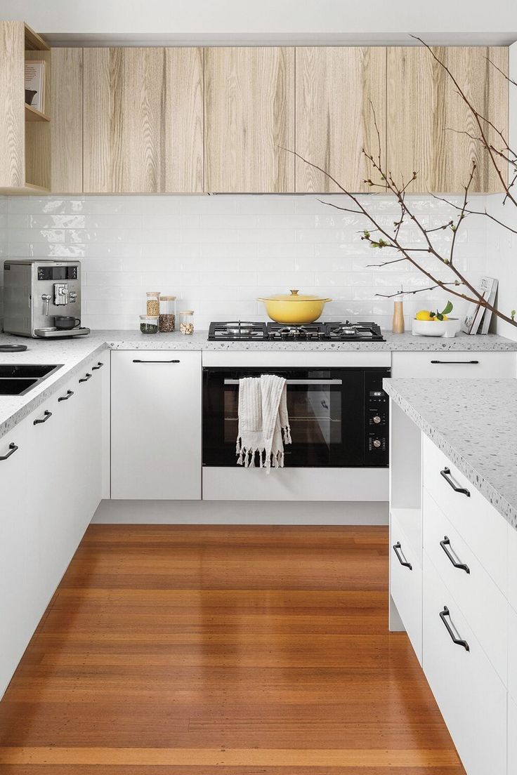 a kitchen with wooden floors and white cabinets