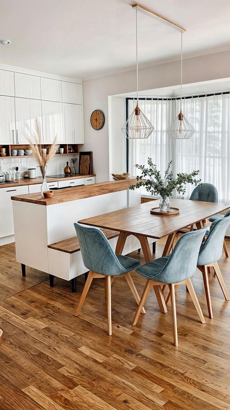 a kitchen with wooden flooring and white cabinetry next to a dining room table