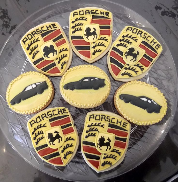 some cookies that are shaped like cars on a glass platter with black and red trim