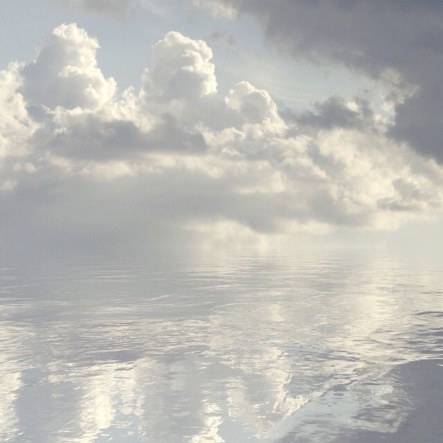 a lone boat floating on top of a large body of water under a cloudy sky