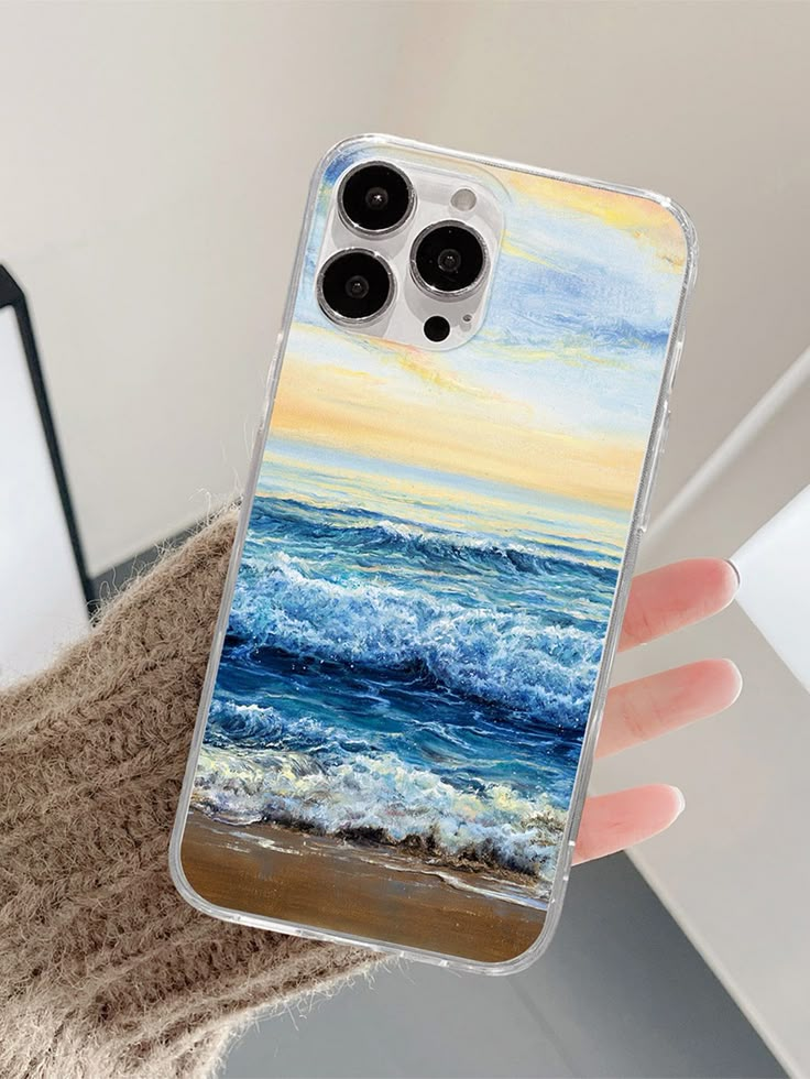 a person holding up a phone case with an ocean scene on it