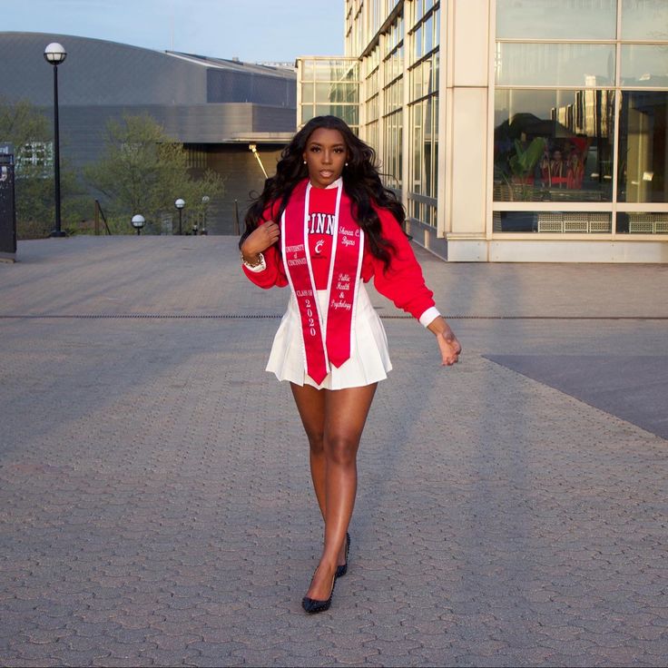 a woman is walking down the street wearing a red and white outfit