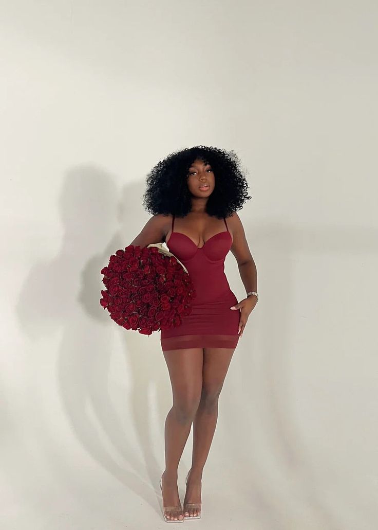 a woman in a red dress holding a bouquet of flowers