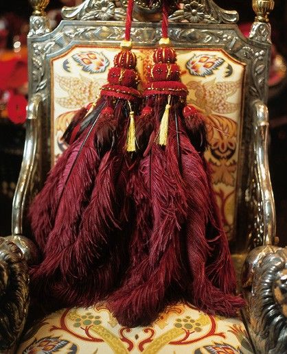 an ornate chair with red tassels on it