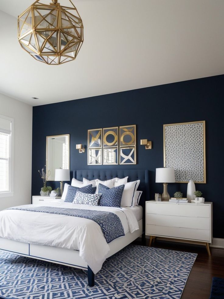 a bedroom with blue walls, white bedding and gold framed pictures on the wall