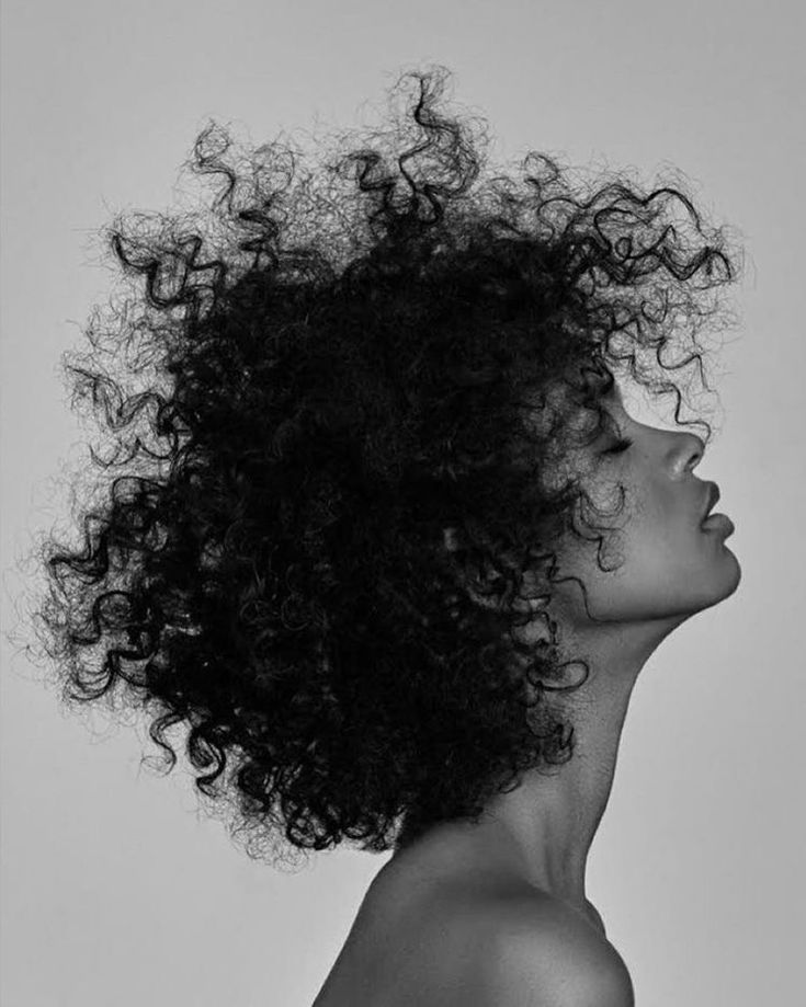 a black and white photo of a woman with curly hair