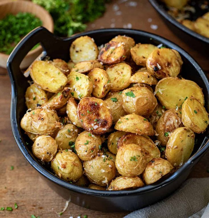 a bowl filled with cooked potatoes on top of a wooden table