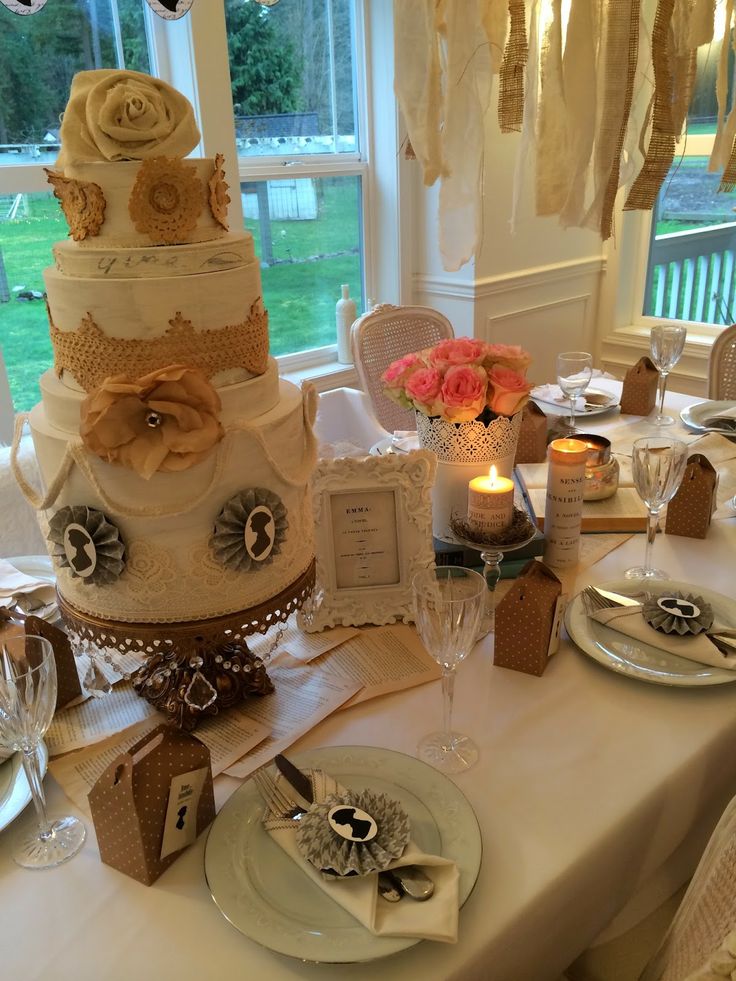 a wedding cake sitting on top of a table next to plates and wineglasses