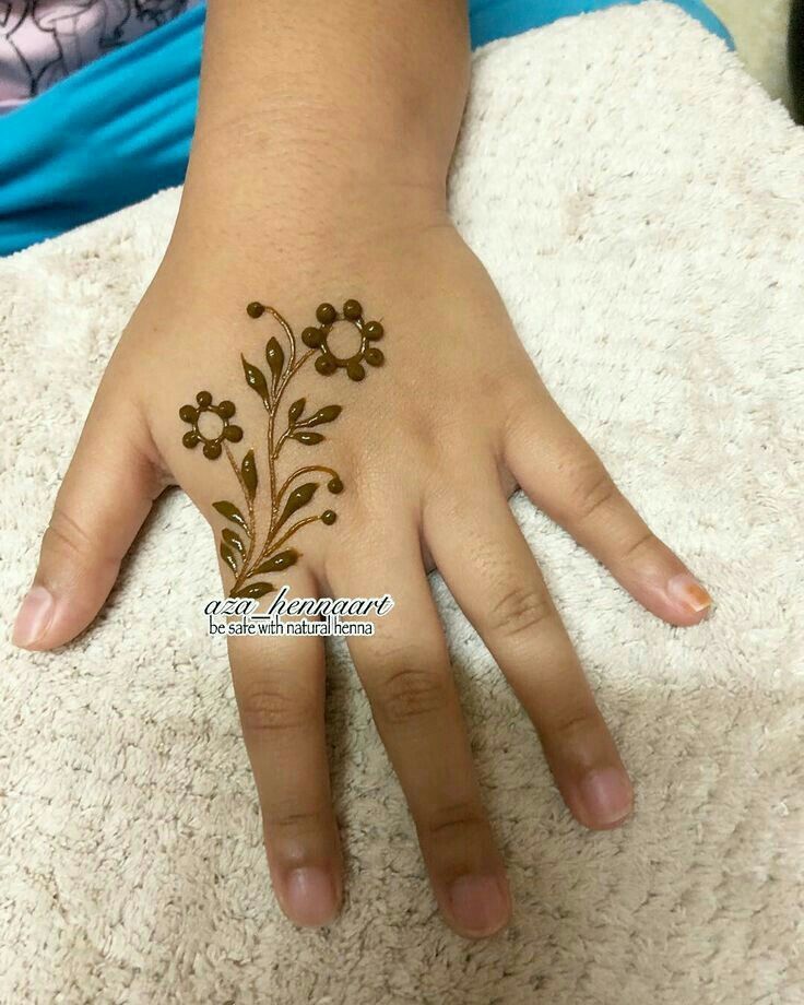 a woman's hand with henna tattoos on it