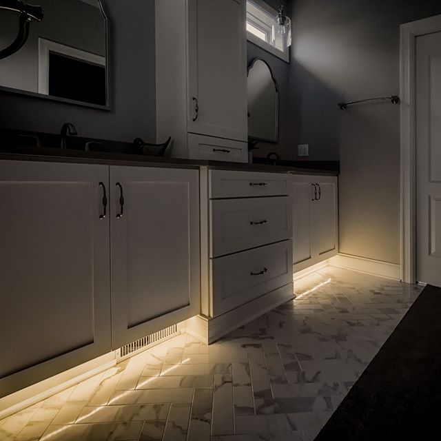 a dimly lit kitchen with white cabinets and black counter tops, is shown in the dark