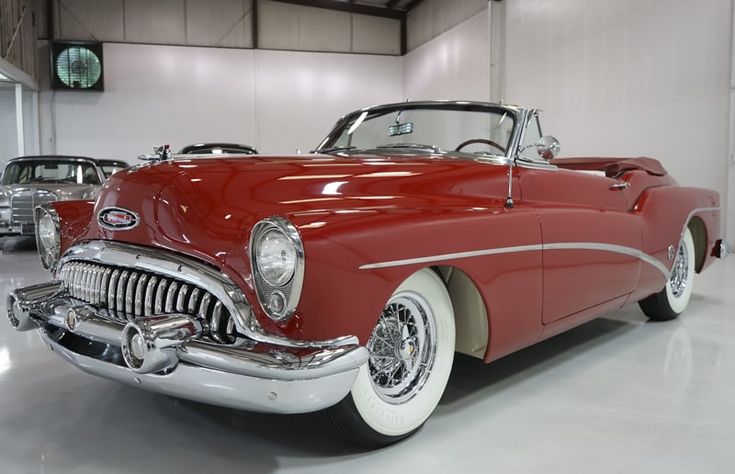 an old red car parked in a garage