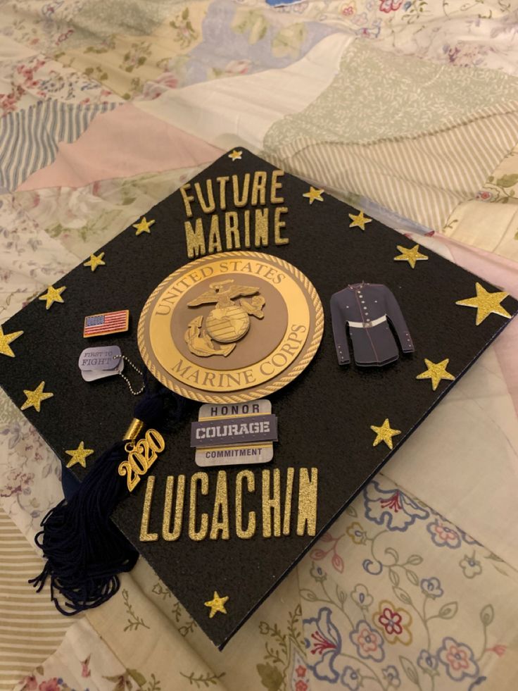 a graduation cap with the words future marine on it sitting on a quilted surface