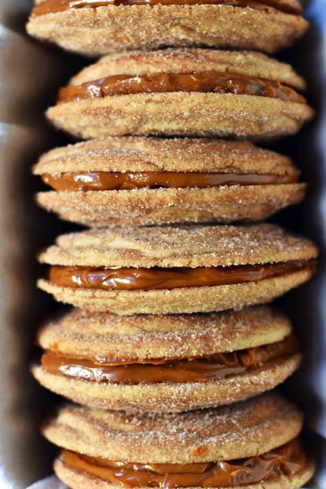 there are many donuts stacked on top of each other in the box and ready to be eaten