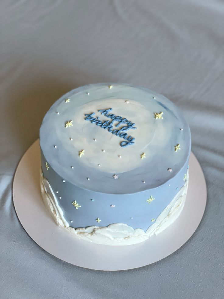 a blue and white birthday cake sitting on top of a table