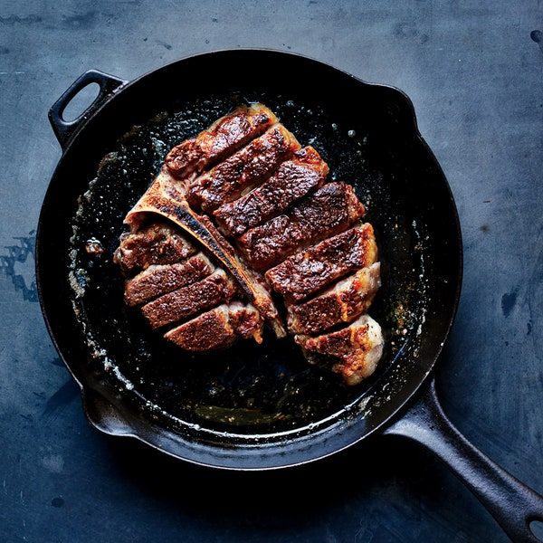 steak cooking in a skillet on a table