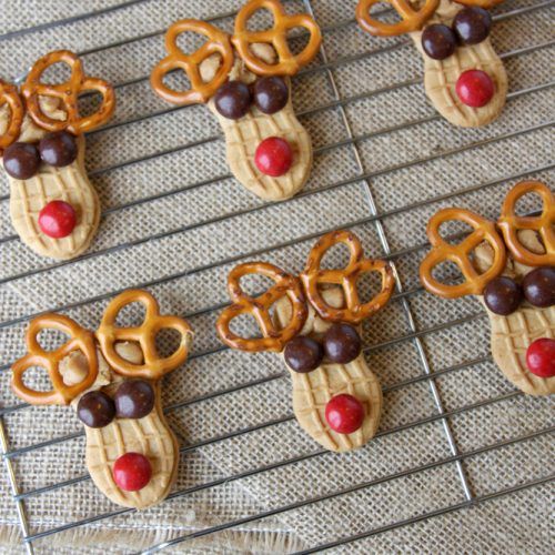 some pretzels are decorated like reindeers and rudolph's nose is sticking out of them