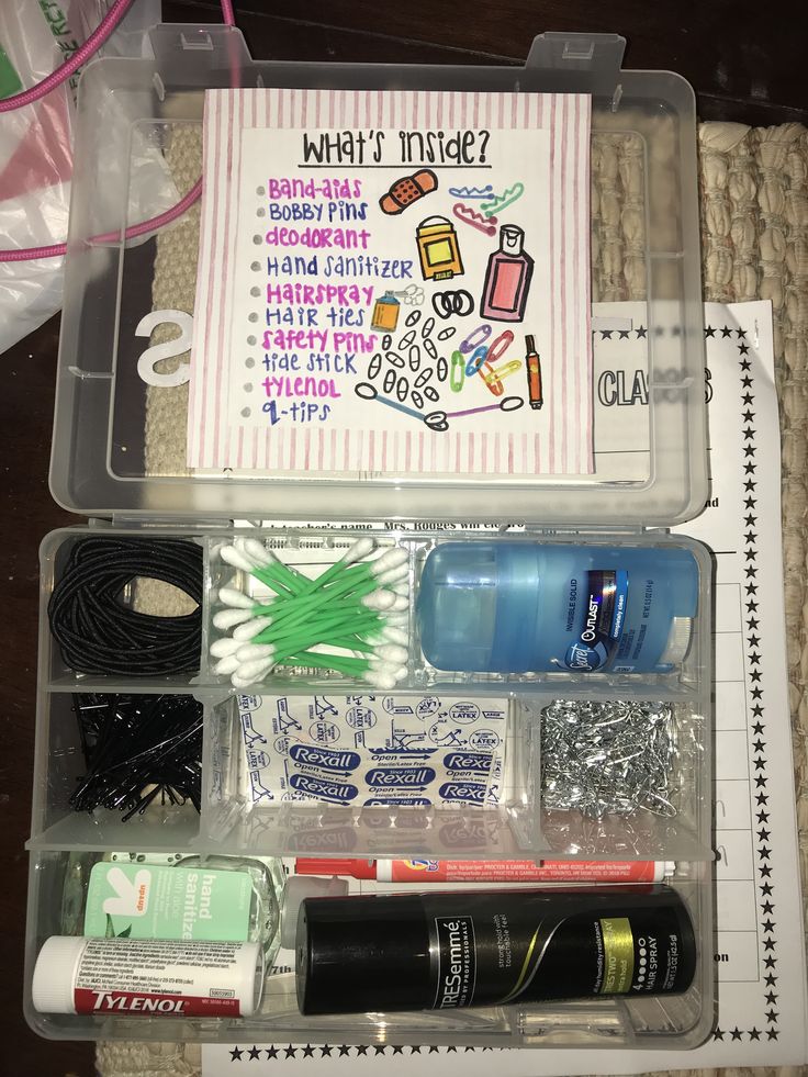 the contents of an organized travel kit in a plastic container on a table with scissors and other items