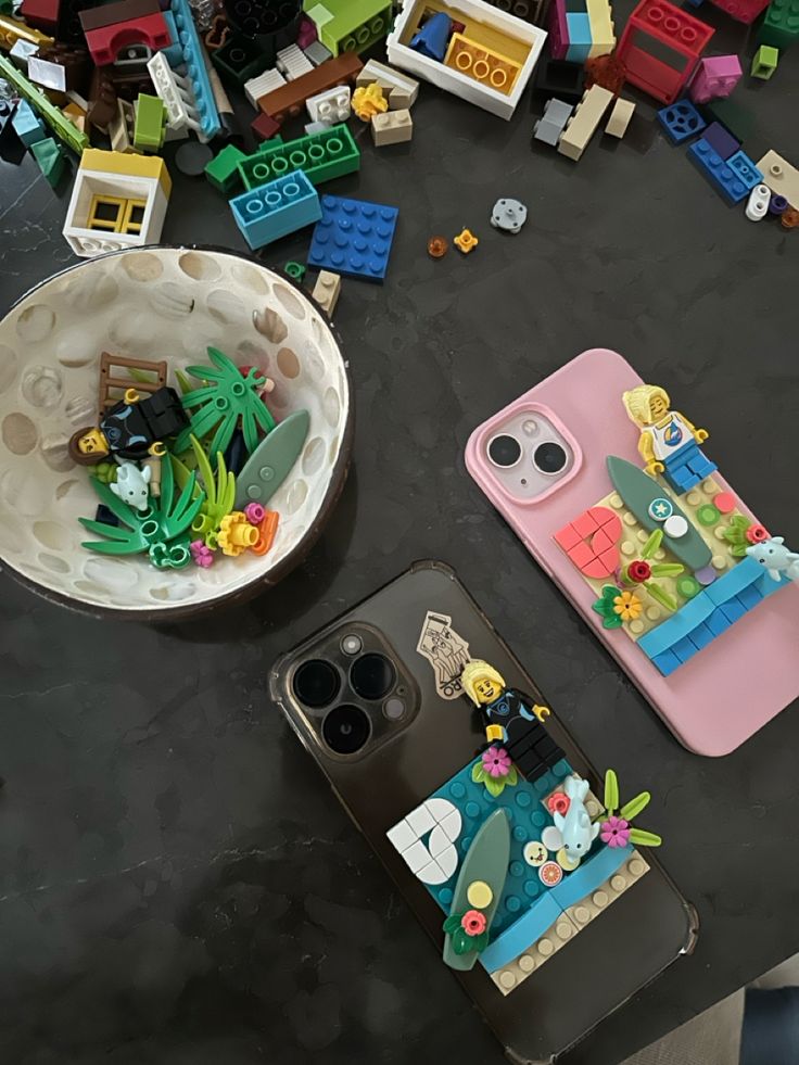 there are many legos on the table next to this cell phone case that is made out of lego blocks