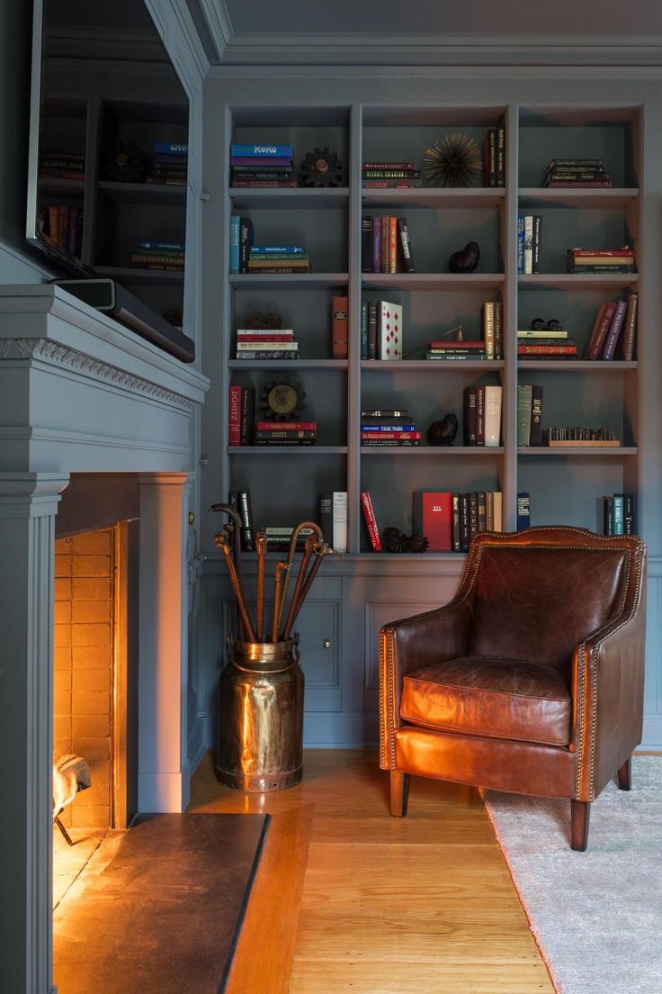 a living room filled with lots of furniture and bookshelves next to a fire place