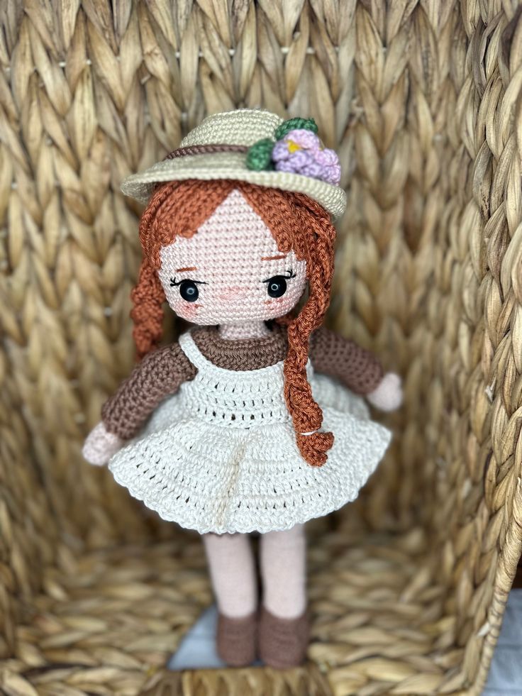 a doll is sitting in a wicker chair with a hat on it's head