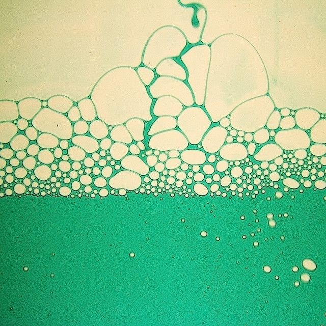 a green and white painting with bubbles on it