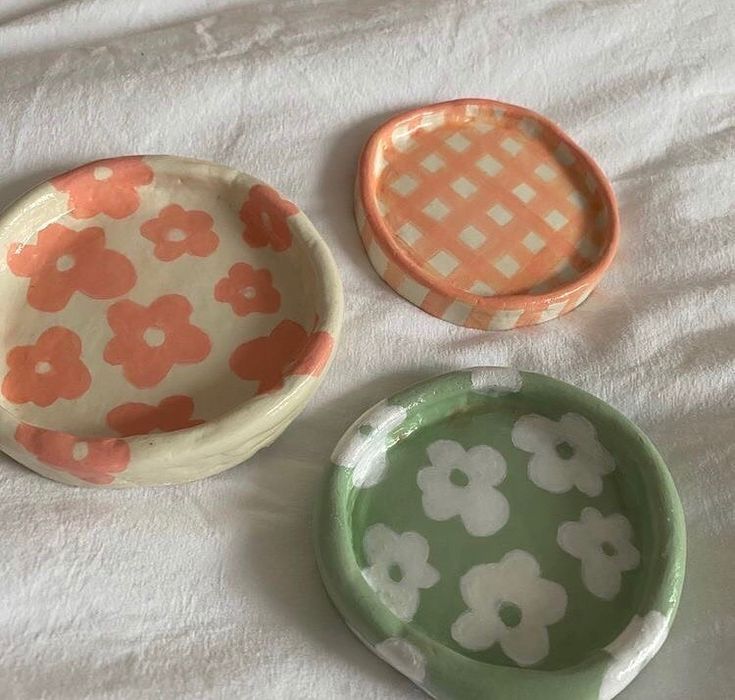 three small dishes sitting on top of a bed