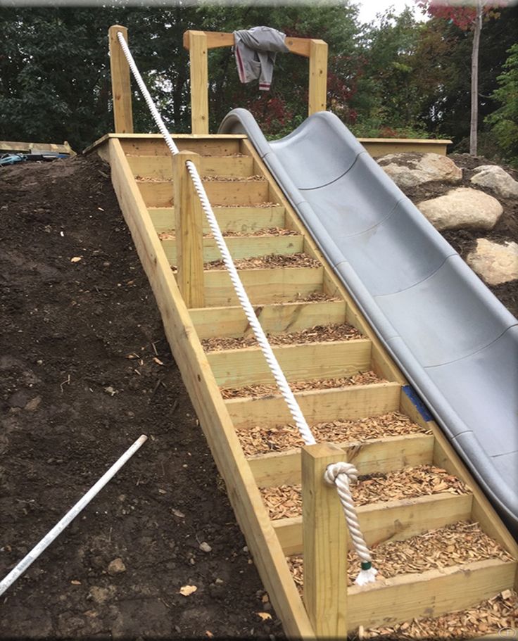 a slide that has been built into the ground with wood chips on it and roped off