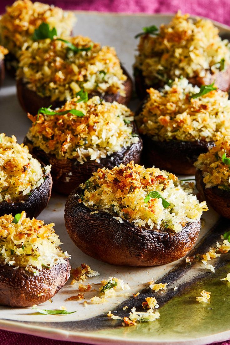 several stuffed mushrooms are on a plate with parmesan and seasoning sprinkles