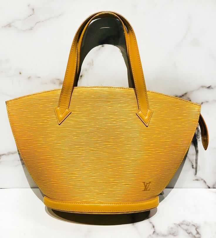 Louis Vuitton Saint Jacques Epi yellow bag in very good condition, with slight wear on the bottom of the bag and one mark on the lining (please see pictures). Approximate Measurements: Size PM, Length 9”, Height 8.5”, Handle Drop 5.5”Made in France. Modern Yellow Shoulder Bag For Formal Occasions, Yellow Business Bags With Gold-tone Hardware, Classic Yellow Formal Bag, Formal Yellow Shoulder Bag With Double Handle, Formal Yellow Bag With Double Handle, Classic Yellow Business Bags, Formal Yellow Double Handle Bag, Formal Yellow Double Handle Bags, Luxury Yellow Bucket Shoulder Bag