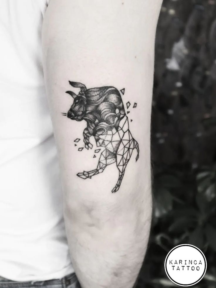 a black and white photo of a bull tattoo on the left upper half of the arm