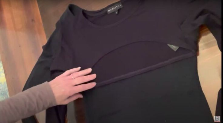 a person holding onto a black t - shirt