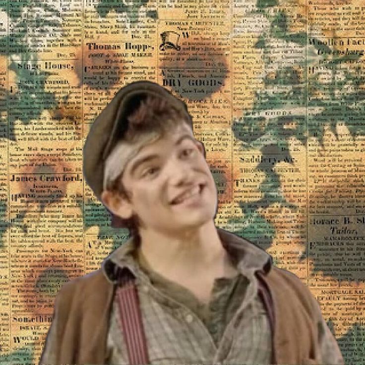 a young man standing in front of a sunflower covered wall with words all over it