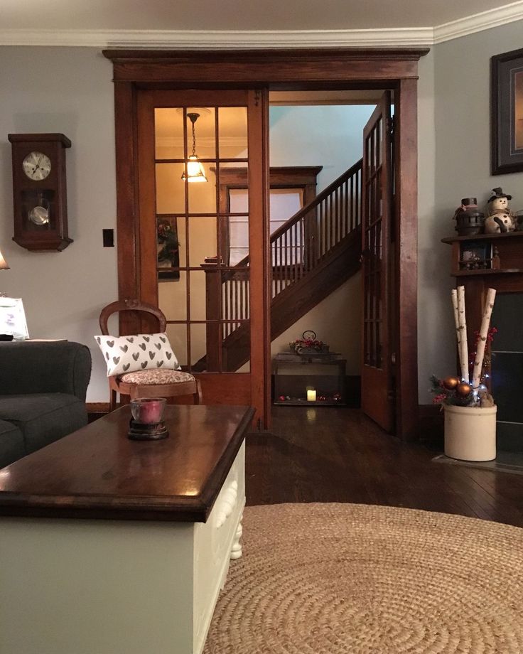 a living room filled with furniture and a fire place in front of a staircase case