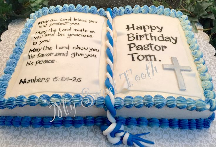 a birthday cake with an open bible on the top and blue ribbon around it that says happy birthday pastor tom