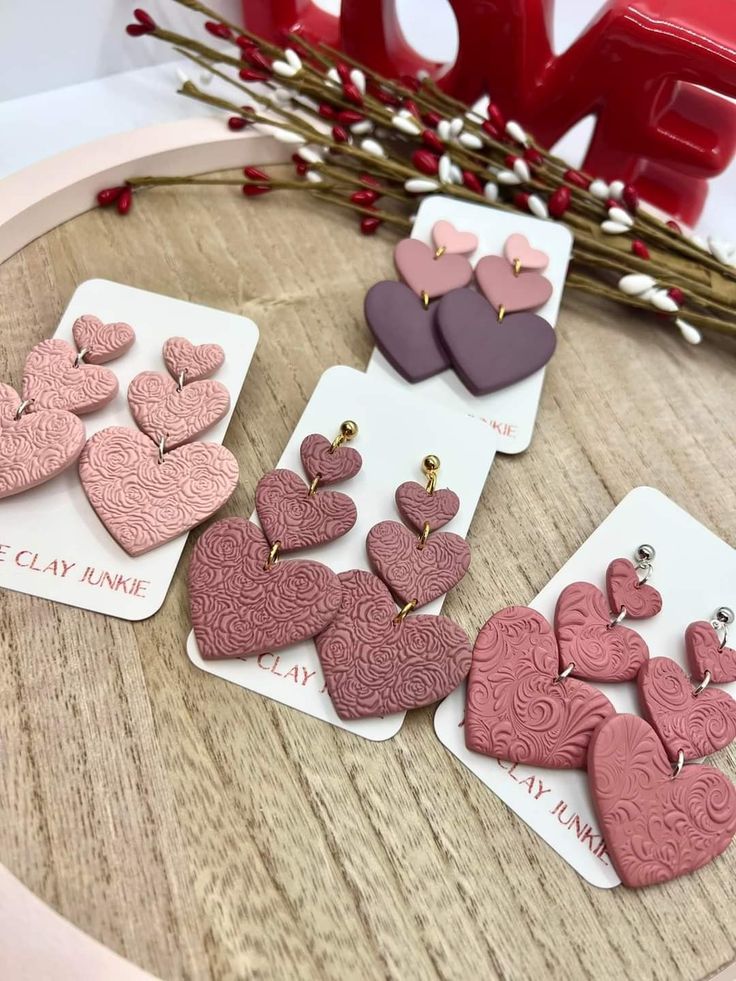 valentine's day cards with hearts on them and flowers in the background, sitting on a table